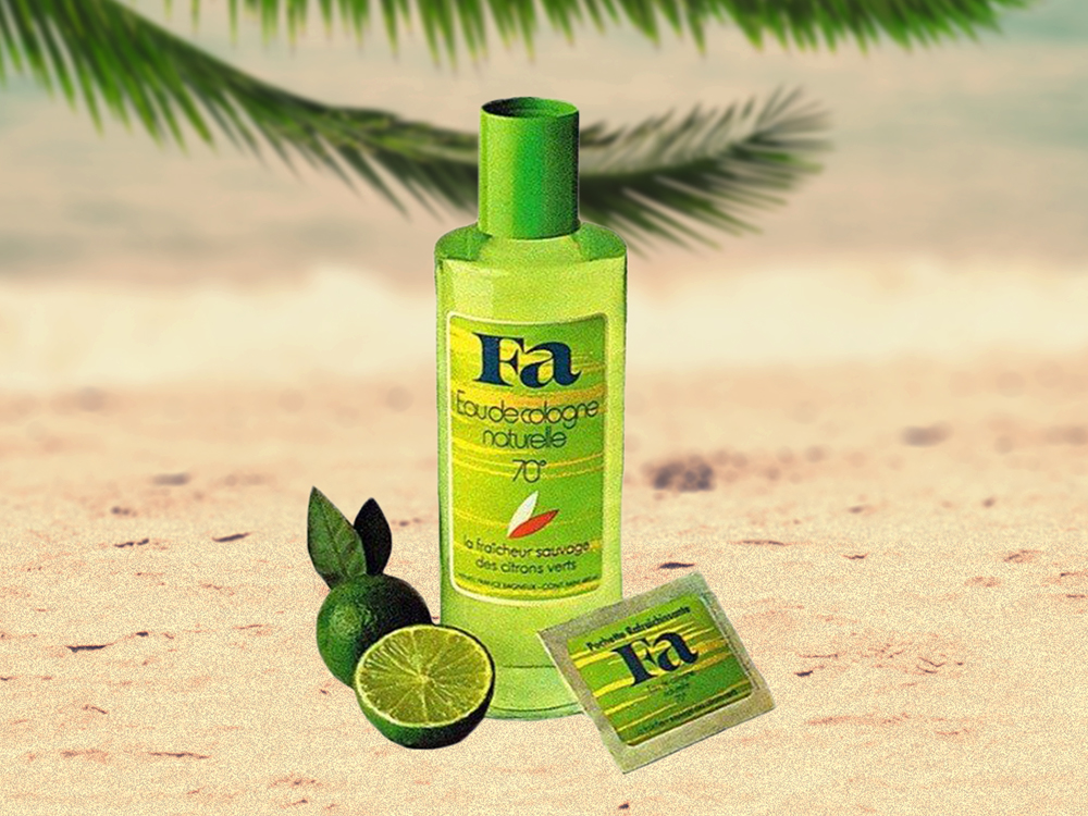 Bile um frasco de desodorante verde claro e um lado embrulhado verde claro com uma lima fatiada em uma praia com uma folha de palmeira.