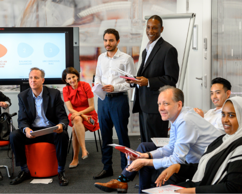 Uma equipe diversificada da Henkel se reúne em um workshop e observa o palestrante