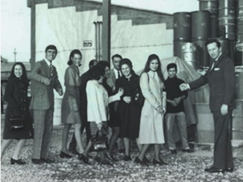 Imagem em preto e branco que mostra a abertura da Henkel Iberica onde vários funcionários apertam a mão do Sr. Henkel.