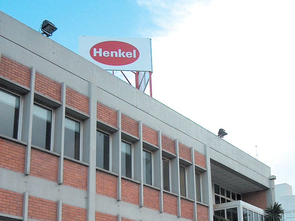 Edifício industrial castanho-branco com um grande logótipo com uma pega oval vermelha no telhado.