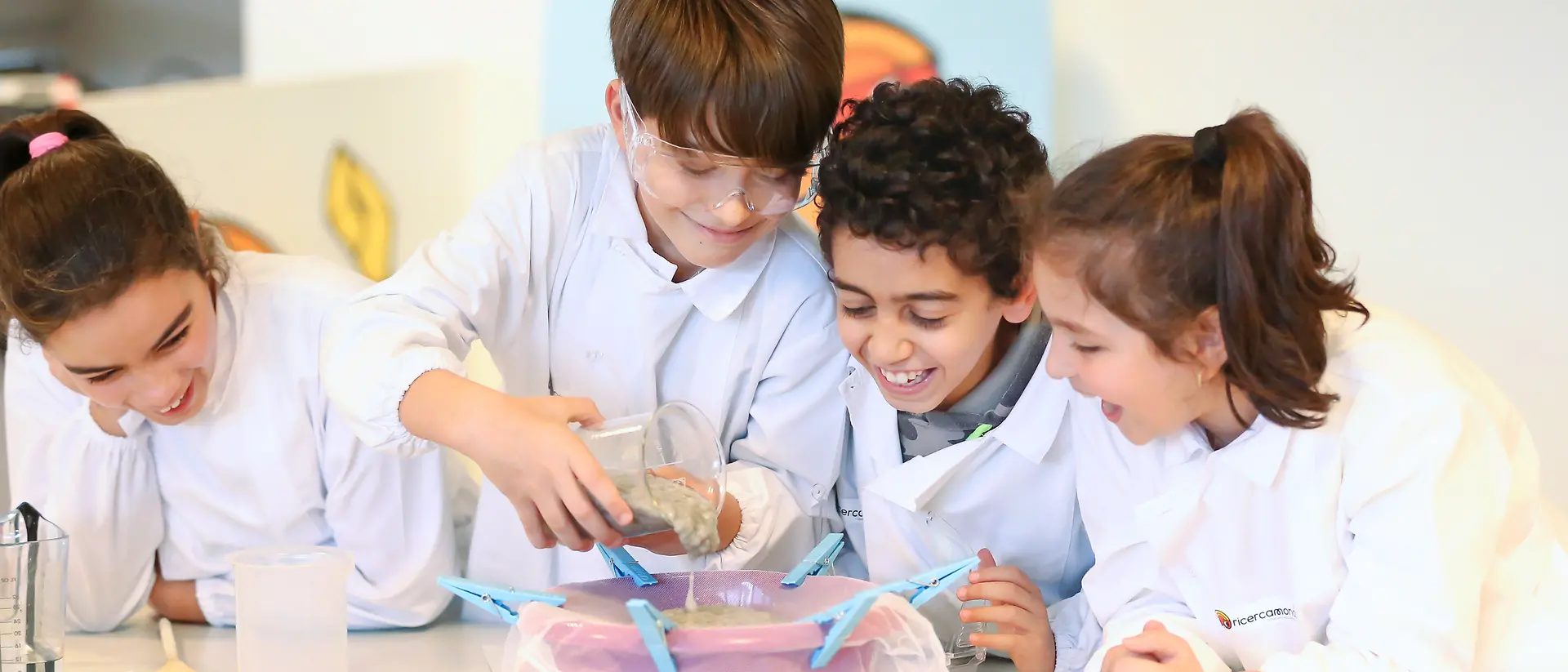 Programa educativo Henkel Researchers' World: 4 crianças a fazer uma experiência