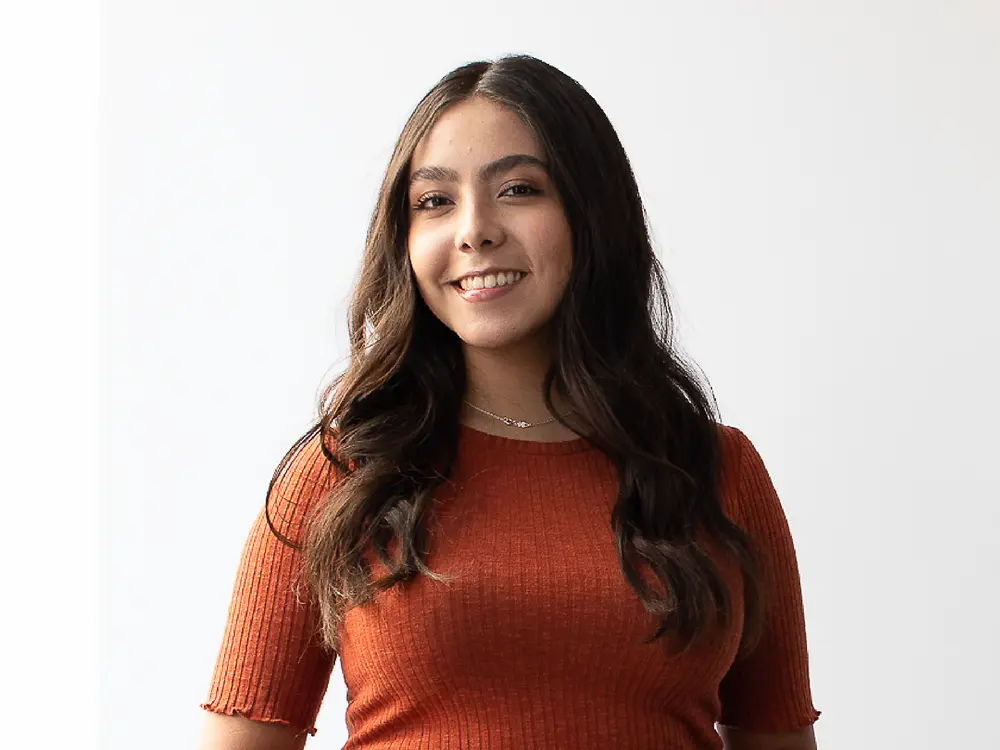 Talent Acquisition Manager do México, vestindo uma camisola laranja canelada de manga curta, a partilhar insights sobre como te destacares no LinkedIn.