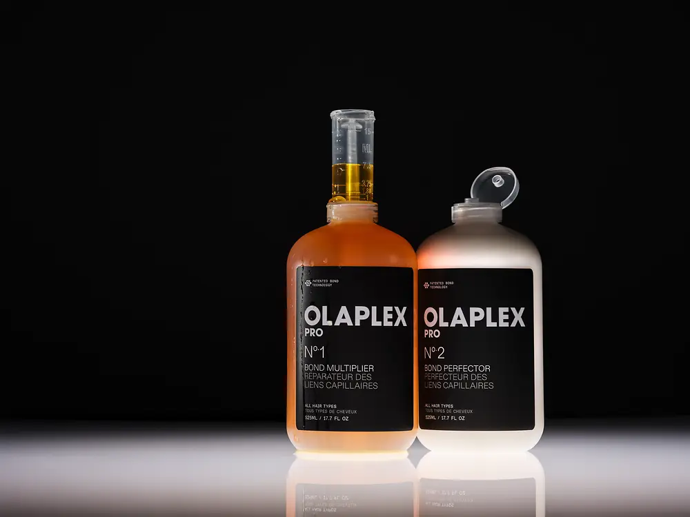 Dois produtos profissionais da Olaplex sobre um fundo preto.