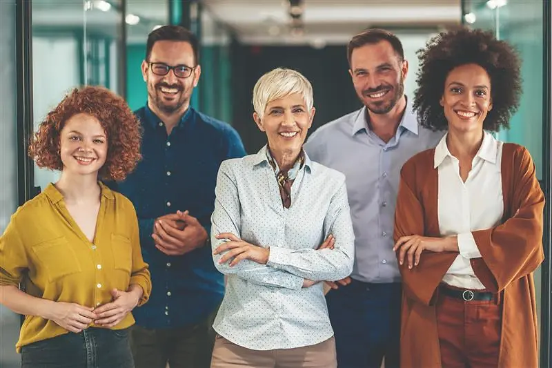 Grupo diverso de profissionais a posar num escritório, representando o objetivo da Henkel de alcançar uma representação equilibrada de mulheres e homens em cargos de gestão até 2030.