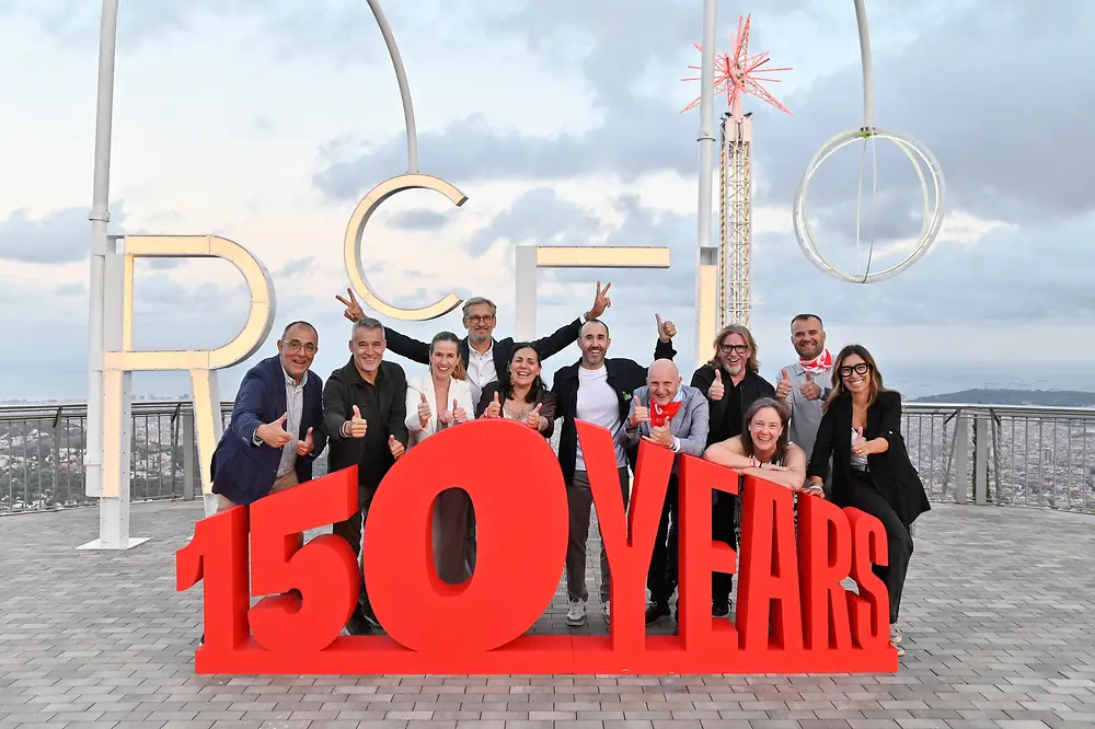 Membros da equipa de direção da Henkel Ibérica posam junto a uma estrutura com a mensagem “150 YEARS” durante o festival comemorativo do 150.º aniversário da Henkel, realizado em Barcelona, com vistas panorâmicas da cidade em segundo plano.